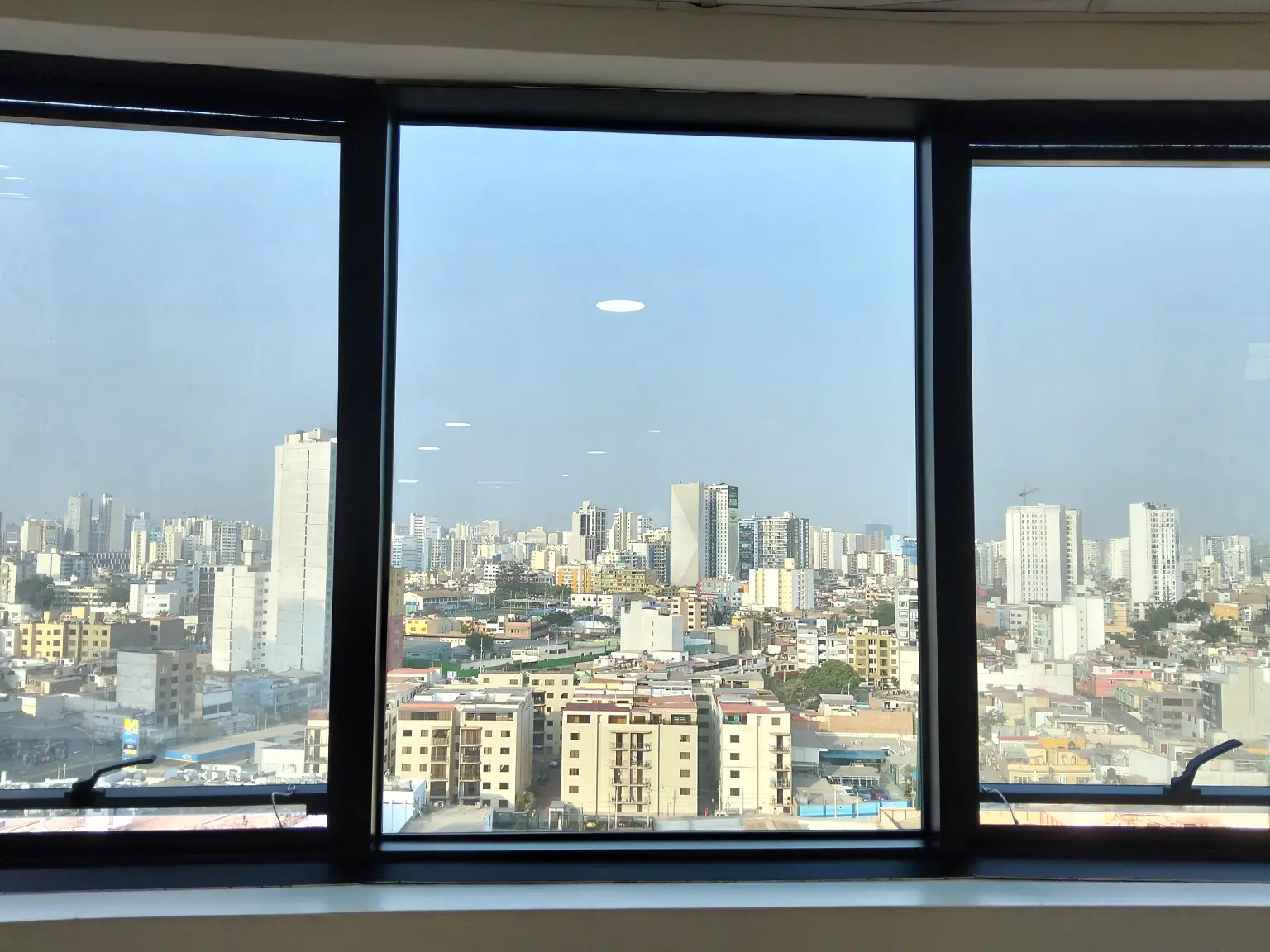 Foto de la ciudad de Lima vistta desde la ventana de un edificio